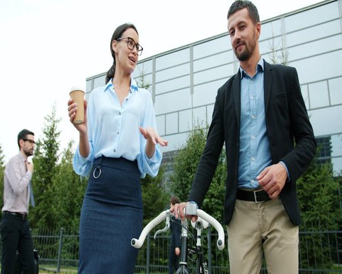 A person locking their bicycle outside an office building